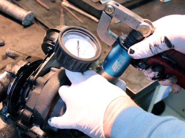 Майстер вимірює люфт вала замасленої турбіни індикатором — дефектування до робіт